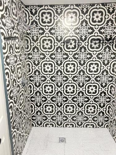 a bathroom with a black and white patterned wall at Pet friendly newly renovated home in Central Okc in Oklahoma City