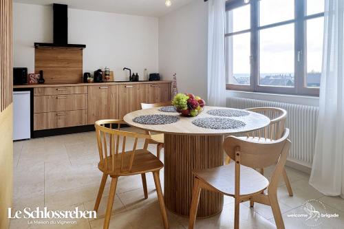 een keuken met een tafel en stoelen met een fruitschaal erop bij Le Schlossreben - La Maison des Vignerons in Orschwiller