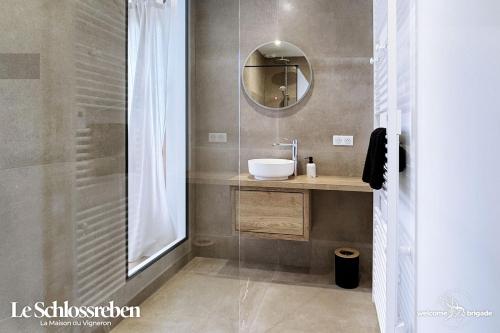 een badkamer met een wastafel en een spiegel bij Le Schlossreben - La Maison des Vignerons in Orschwiller