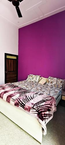 a bedroom with a purple wall and a bed at Angel hill resort in Chonp