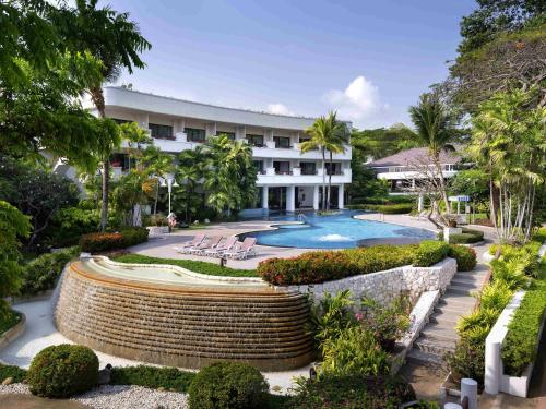 een resort met een zwembad en een gebouw bij Novotel Rayong Rim Pae Resort in Klaeng