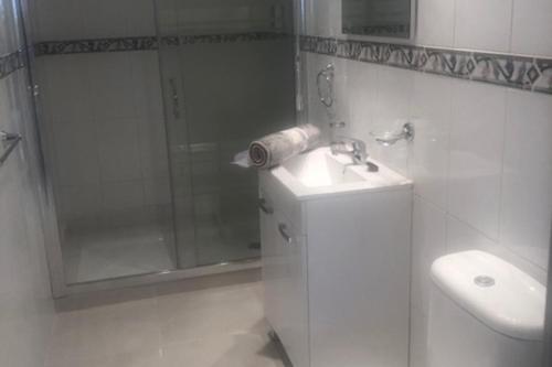une salle de bain avec douche, lavabo et toilettes dans l'établissement 2 Bed Apartment Sleeps 6 -Public pool and Patio, à La Cala de Mijas