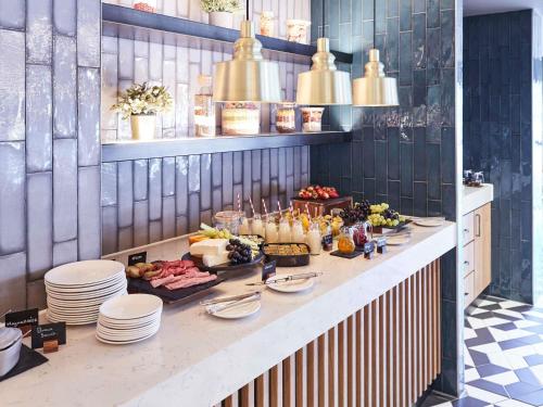una línea de buffet con comida y platos en una mesa en Novotel Birmingham Airport Terminal Building - NEC, en Bickenhill