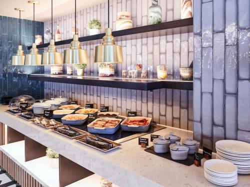 una línea de buffet con platos y comida en una mesa en Novotel Birmingham Airport Terminal Building - NEC, en Bickenhill