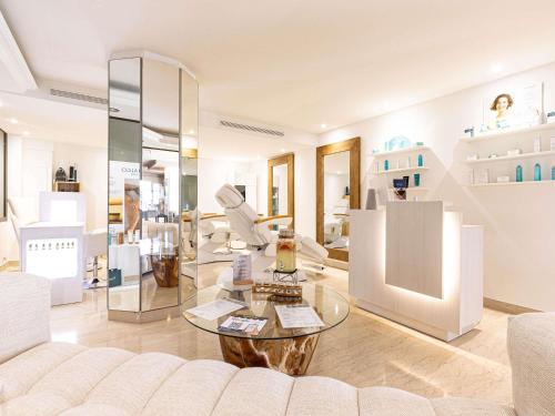 un salon avec un canapé et une table en verre dans l'établissement Pullman Cannes Mandelieu, à Mandelieu-la-Napoule