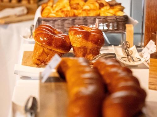 Un grupo de croissants y una cesta de pan. en Pullman Cannes Mandelieu, en Mandelieu-la-Napoule