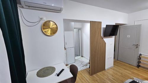 a room with a clock on the wall and a table at Next to Coco's Apartment in Tirana