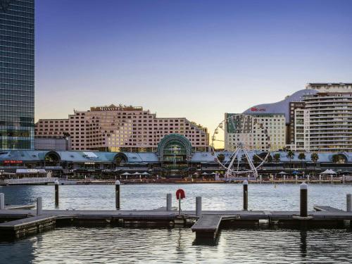 a marina with a dock in the water with buildings at Novotel Sydney Darling Harbour in Sydney