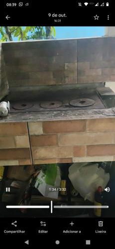 a stove top oven sitting under a wooden table at Casa tranquila Itanhaém in Itanhaém