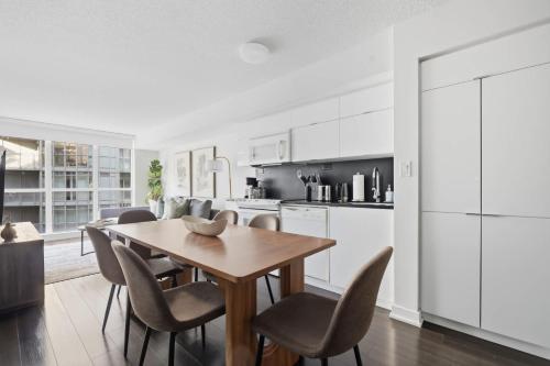 a kitchen and dining room with a wooden table and chairs at Trendy 1BR Condo Free Parking Downtown Toronto in Toronto