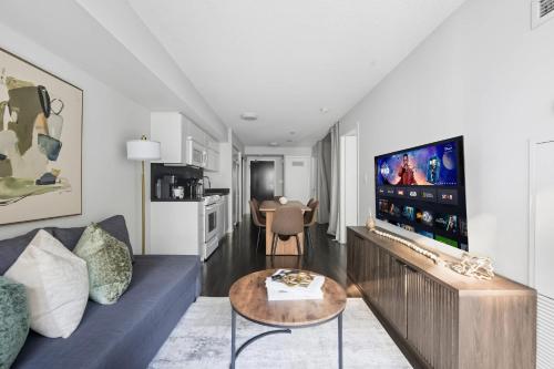 a living room with a blue couch and a tv at Trendy 1BR Condo Free Parking Downtown Toronto in Toronto