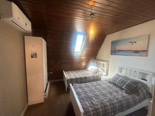 a bedroom with two beds in a room with wooden walls at Umm Aljulud Cottages 02 in Ajloun
