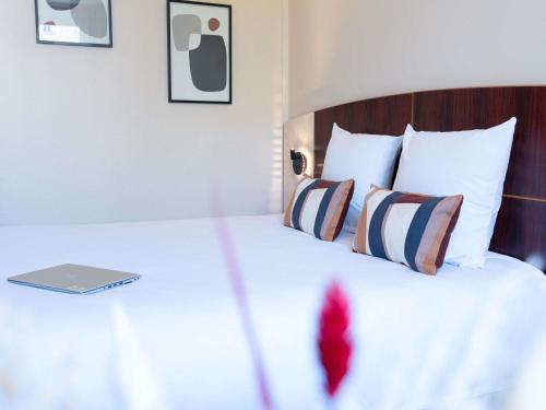 a bedroom with a bed with a laptop on it at Mercure Besancon Parc Micaud - Hotel & Bar in Besançon