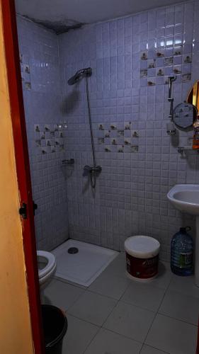 a bathroom with a shower with a toilet and a sink at Résidence Ndackel in Kammba