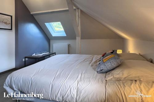 Un dormitorio con una cama con una almohada encima. en Le Hahnenberg - la Maison des Vignerons, en Orschwiller