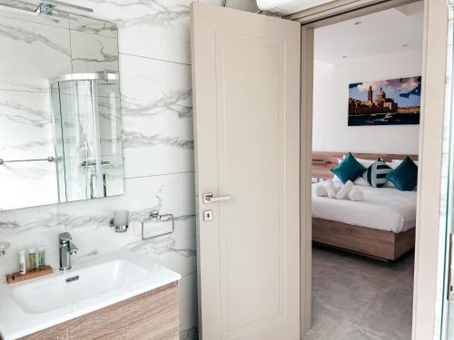 a bathroom with a sink and a mirror and a bed at Modern Escape Villa in St Julian with Pool by ArcoBnb in St Julian's