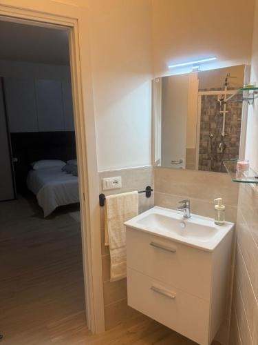 a bathroom with a sink and a mirror and a bed at Casa La Perla in Montevarchi