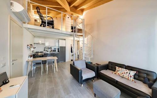 a living room with a couch and a dining room at Relais Fasanella attico - Lago di Garda in Toscolano Maderno