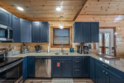 a kitchen with blue cabinets and a sink at Luxury Cabin with Hot Tub and Resort Access in Sevierville