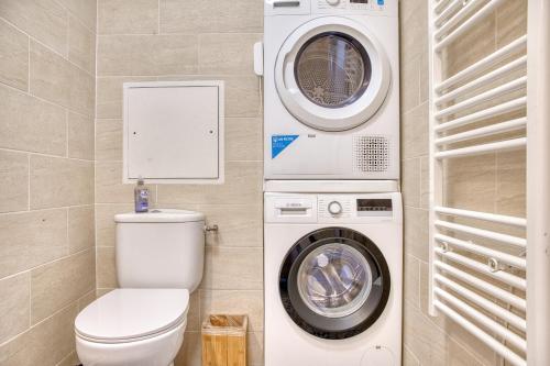 a bathroom with a washing machine and a washer at Le Duplex - Disneyland - Rooftop - Wifi in Montévrain
