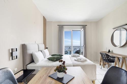 a living room with a bed and a table at Sunset Premium Studio A in Agios Nikitas