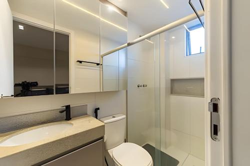 a bathroom with a toilet and a sink and a mirror at Edifício Mosaico do Mar - Seu Refugio na Praia da Jatiúca in Maceió