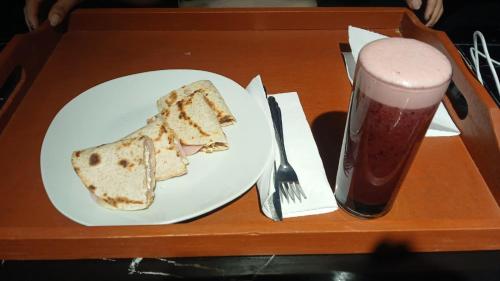 een bord met een sneetje brood en een glas frisdrank bij Thalu House in Pacasmayo