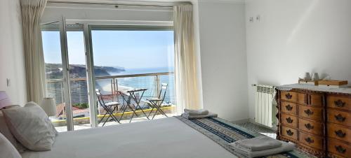 a bedroom with a bed and a view of the ocean at Mega Ocean Magoito - Guest House - Sintra in Sintra