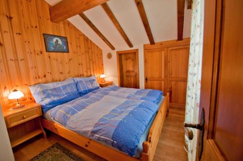 a bedroom with a bed in a room with wooden walls at Furggen, Chalet Museum in Grächen