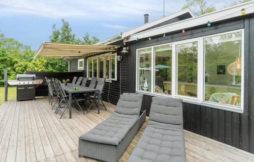 a black house with a deck with a table and chairs at 2 Bedroom Awesome Home In Hasle in Hasle