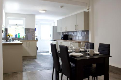 a kitchen with a black table and chairs in a room at The Robinwood Green Haven Retreat Luxurious 3 Bedroom Stay Sleeps 7 in Nottingham