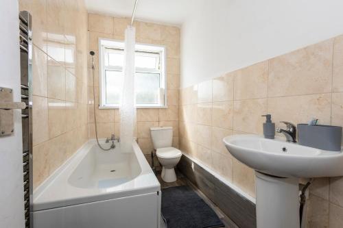 a bathroom with a sink and a tub and a toilet at The Robinwood Green Haven Retreat Luxurious 3 Bedroom Stay Sleeps 7 in Nottingham