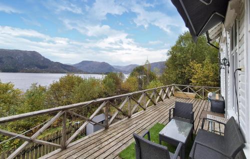 a deck with chairs and a view of a lake at Beach Front Home In Vaksdal With House Sea View in Stavenesli