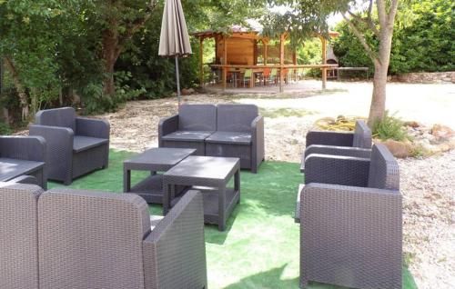 un groupe de chaises, de tables et d'un parasol dans l'établissement Gorgeous Home In Les Mages, à Les Mages