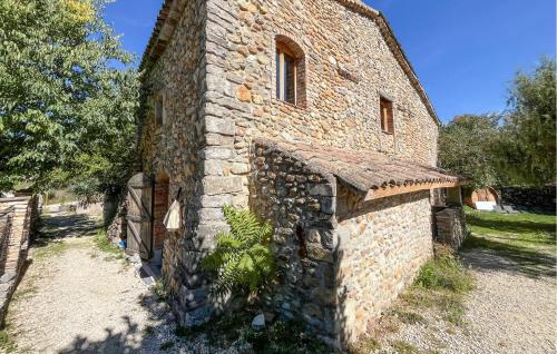 un vieux bâtiment en pierre avec une plante devant dans l'établissement Gorgeous Home In Les Mages, à Les Mages