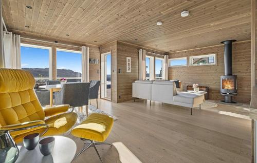 a living room with yellow chairs and a fireplace at Beautiful Home In Sannidal With Lake View in Neslandsvatn