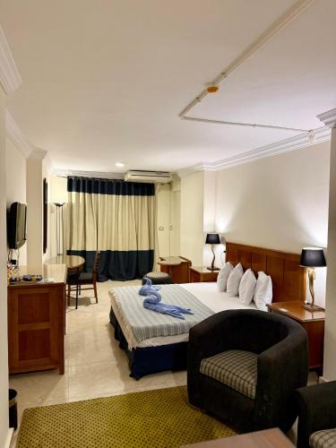 a bedroom with a bed and a couch and a chair at Bianchi Hotel in Alexandria