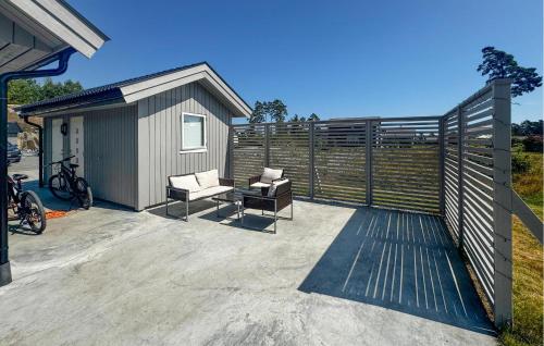 ein kleiner Schuppen mit zwei Stühlen auf einer Terrasse in der Unterkunft 4 Bedroom Lovely Home In Færvik in Gjerstad