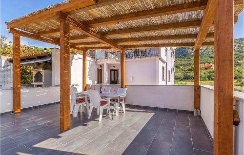 a wooden pergola on a patio with a table and chairs at Cozy Apartment In Baska With Swimming Pool in Draga Bašćanska