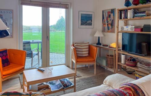 a living room with a couch and a tv at Awesome Apartment In Hals With House A Panoramic View in Skovsgård