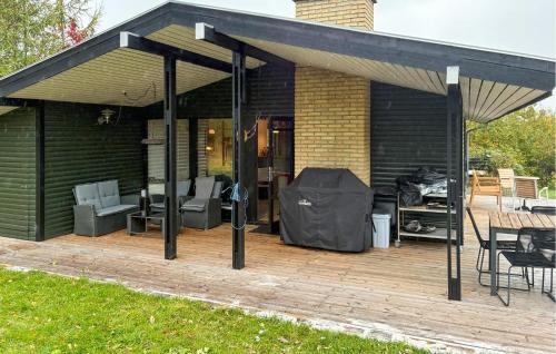 VejbyにあるAmazing Home In Vejby With Wifiの木製デッキに椅子とテーブルを配置したパビリオン
