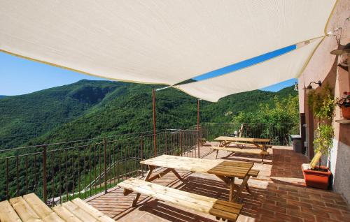 a balcony with picnic tables and a view of a mountain at Lovely Home In Castelletta in Precicchie