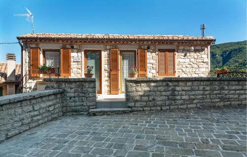 a stone house with a stone wall and a fence at Lovely Home In Castelletta in Precicchie