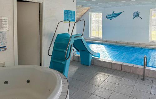 a bathroom with a tub and a swimming pool at Lovely Home In Væggerløse With Sauna in Marielyst
