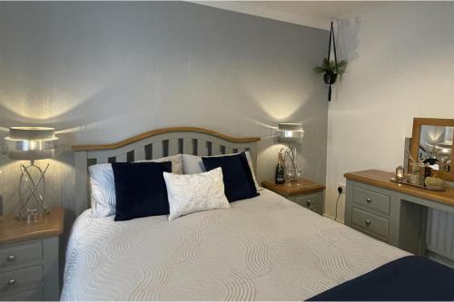 a bedroom with a bed with blue and white pillows at 2 Bed House - Sleeps 4 - Garden Parking Wifi in Perth