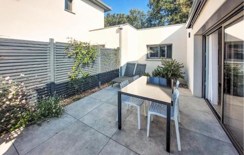 a patio with a table and chairs and a fence at Lovely Home In Jard Sur Mer With Wifi in Jard-sur-Mer