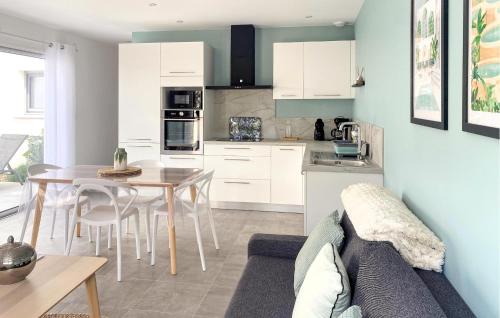 a kitchen and dining room with a table and a couch at Lovely Home In Jard Sur Mer With Wifi in Jard-sur-Mer
