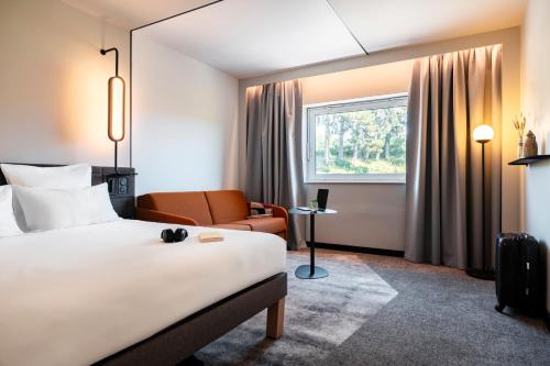 una habitación de hotel con una cama y una silla en Novotel Belfort Centre Atria, en Belfort