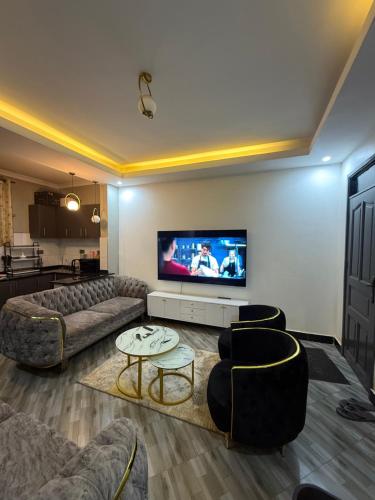 a living room with couches and a flat screen tv at Trustbridge in Kampala