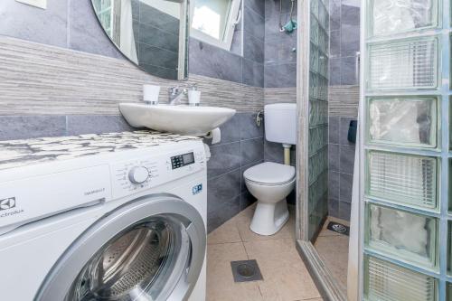 a bathroom with a washing machine and a sink at House Osti in Rogoznica